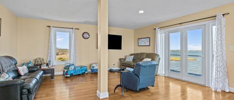 A spacious living area with a sofa, armchair, and a small table.