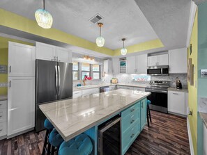 A modern kitchen with a large island, stainless steel appliances, and pendant lighting. - Beach Retreat: 3  BR, 2  BA House in Crystal Beach, Sleeps 12 (Crystal Beach)
