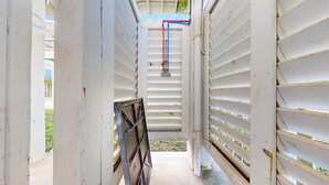 A narrow corridor with white walls and a metal gate at the end. - Candy's Cove: 2  BR, 1  BA House in Crystal Beach, Sleeps 8 (Crystal Beach)