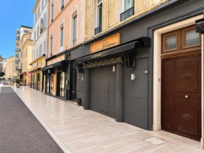 Una hilera de edificios con escaparates, incluyendo un restaurante llamado 'La Bohème' con un toldo negro.