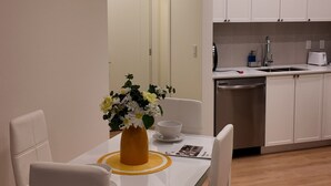 A modern kitchen with white cabinets, a sink, and a countertop. - The Central Luxe (Surrey)
