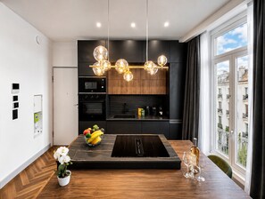 A modern kitchen with a built-in oven, microwave, and a fruit bowl on the counter. - GIGI Urban Chic Centre Cannes Croisette on foot (Cannes)