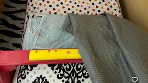 Un petit lit avec un tapis à motifs z ébrés, un oreiller blanc et une couvre-lit à pois.