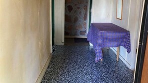 Un couloir étroit avec une table à carreaux et un mur en pierre.