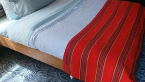 Une chambre avec un lit, une autre chambre avec une table, et une moustiquaire.