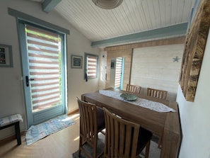 A dining area with a wooden table, chairs, and a patterned table runner.