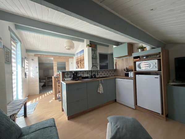 A compact kitchen with a central island, a microwave, and a dishwasher.