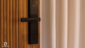 Una puerta con un picaporte negro y un panel de madera vertical.