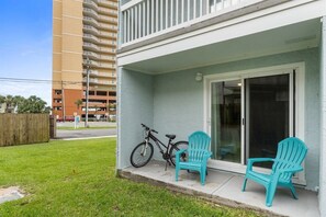 Ein Gebäude mit einem Balkon, einem Fahrrad und zwei Stühlen.