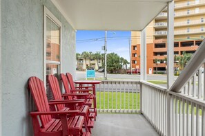 Ein Balkon mit roten Adirondack-Stühlen und einem Schild für Woodwood.