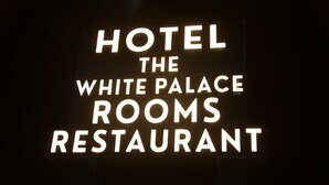 A sign with the text 'HOTEL THE WHITE PALACE ROOMS RESTAURANT'. - Hotel The White Palace (Lakhpat)