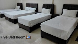 A five-bed room with individual beds, each with a black headboard and white bedding. - Hotel The White Palace (Lakhpat)