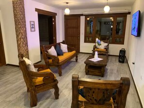 A living room with wooden furniture, a television, and a speaker. - Villa del Carmen, Colonial House (Villa de Leyva)