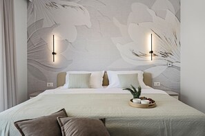 Ein Schlafzimmer mit einem großen Bett, zwei Wandleuchten und einer Wanddekoration.