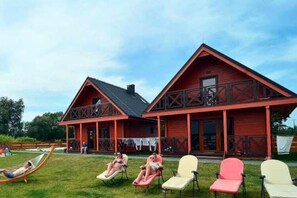 Ein rotes Holzhaus mit Balkon und überdachter Veranda.