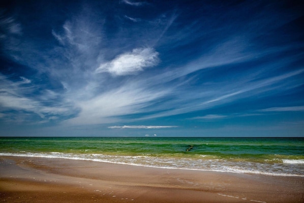 Una playa con cielo despejado y océano.