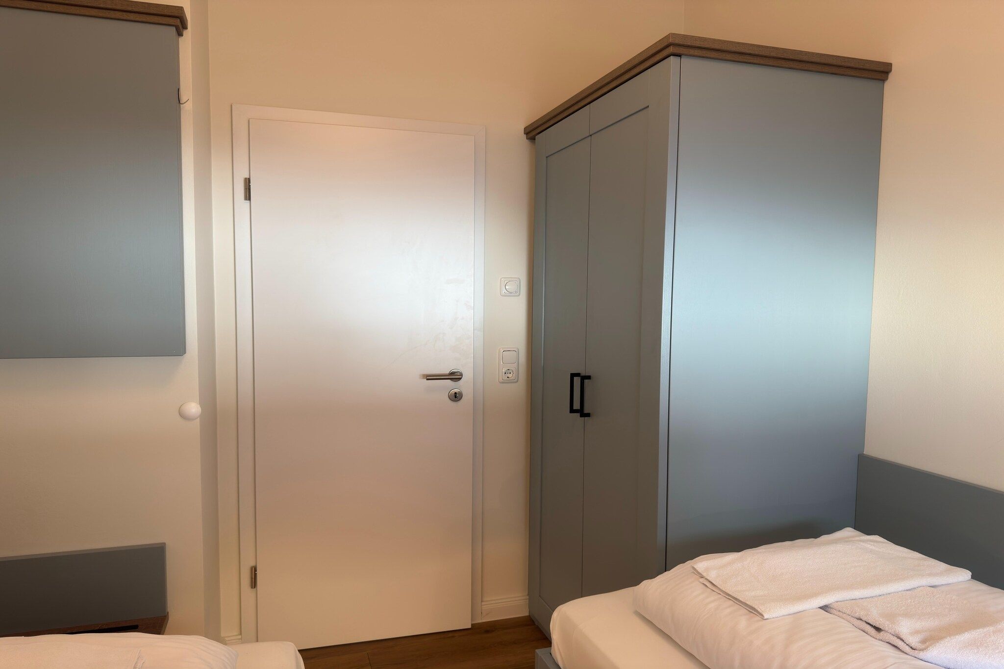 Une chambre à coucher avec un lit, une armoire et une porte.