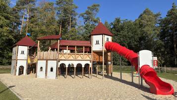 A playground with a castle-like structure, including a slide and climbing areas.