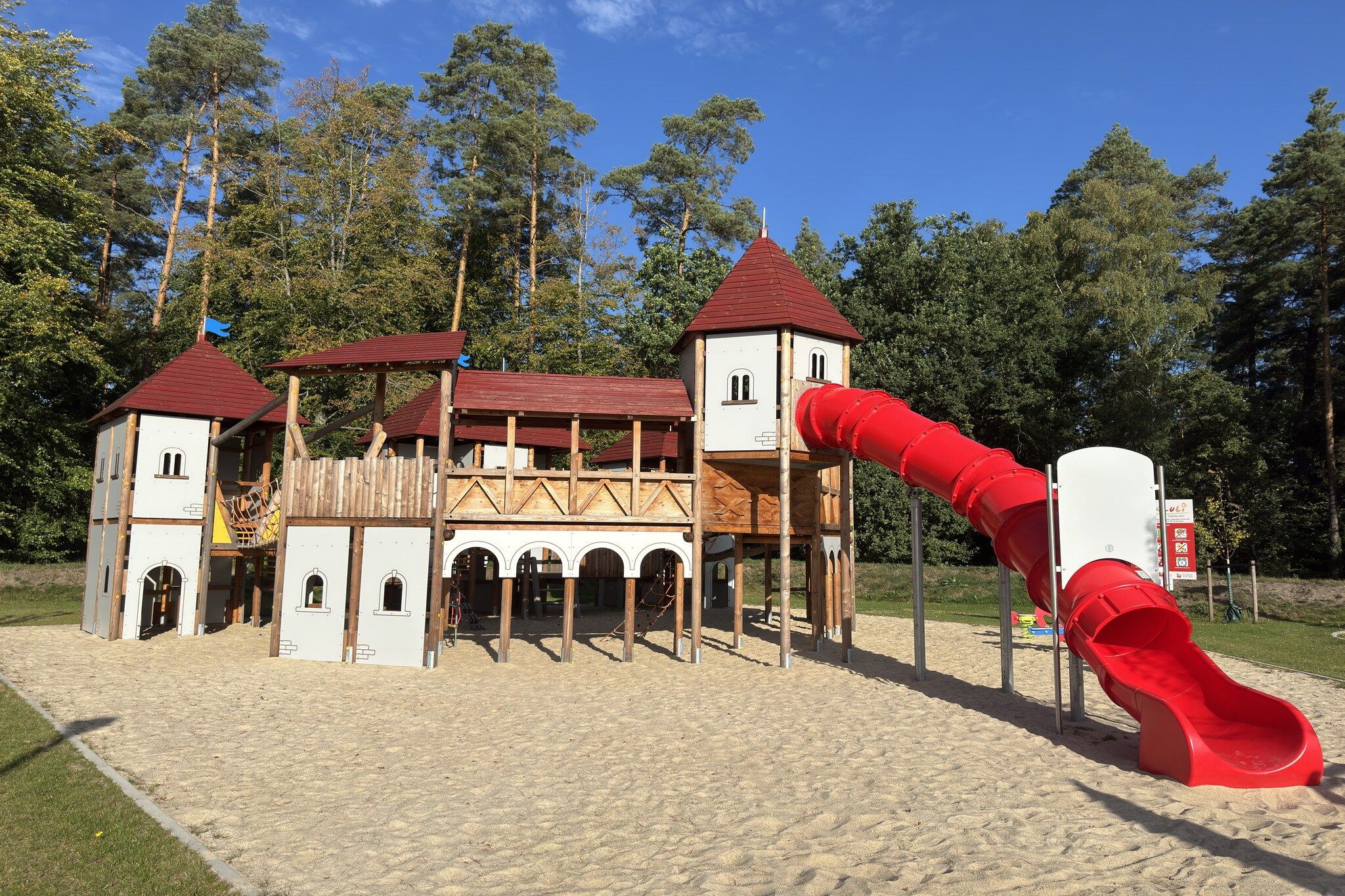 Ein Spielplatz mit einer burgähnlichen Konstruktion, inklusive Rutsche und Kletterbereichen.