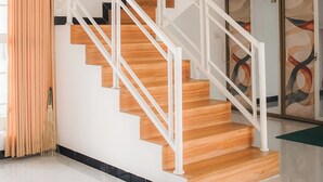 Eine moderne Treppe mit Holzdielen und weißen Geländern, die zu einer oberen Etage führt.