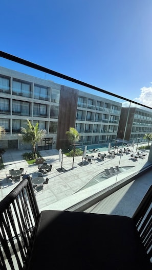 A modern building with a pool area, outdoor seating, and a view of the sky.