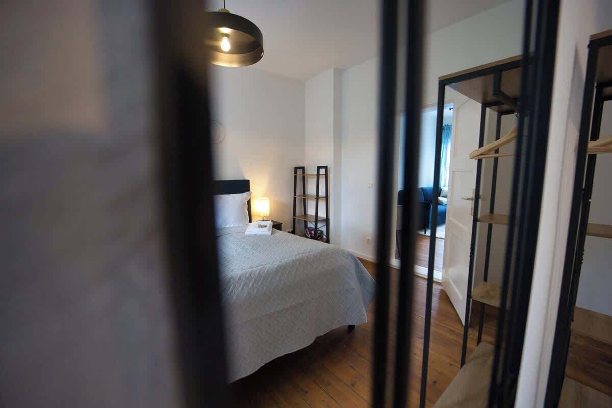 Et soveværelse med seng, natbord, lampe og garderobeskab.