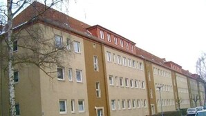 Un immeuble à plusieurs étages, caractérisé par un style architectural uniforme, avec une série de fenêtres et un toit plat.