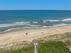Ein Strand mit Sandküste, Wellen und blauem Himmel.