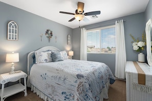 A bedroom with a bed, a nightstand, a dresser, a ceiling fan, and a window with blinds. - Desert Family Oasis, Pool, Spa & Kids’ Paradise (Avondale)