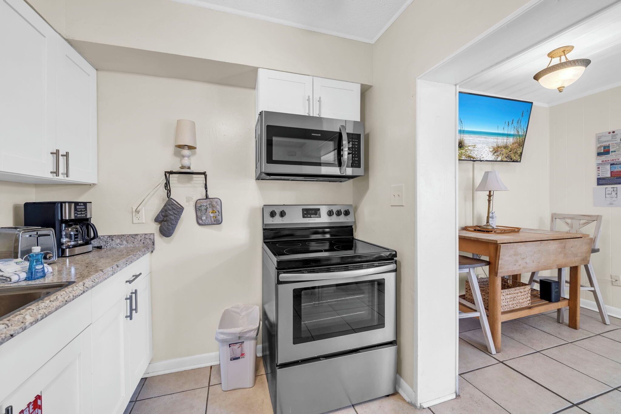 A compact kitchen with a microwave, oven, and coffee maker.