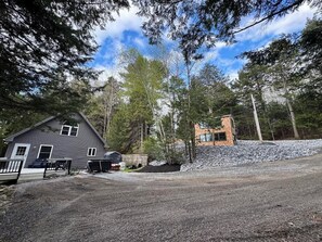 Ein zweistöckiges Haus mit einem Schotterweg und einem kleinen Garten.