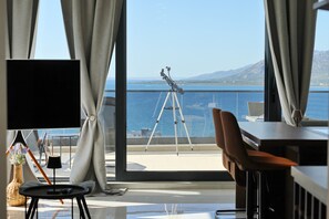 Ein Zimmer mit großem Fenster, Stativ, Stuhl und Tisch.