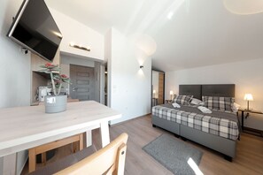 A modern bedroom with a bed, bedside tables, a flat-screen TV, a desk, and a potted plant. - Villa Jimmy with Heated Pool (Starigrad)