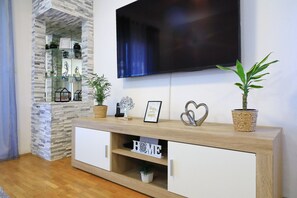 Ein Wohnzimmer mit Fernseher, Holzschrank und Dekoration.