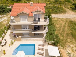 Un edificio a più piani con piscina, balconi e mobili da esterno.
