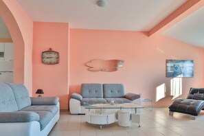 Ein Wohnzimmer mit einer Couch, einem Couchtisch, einer Uhr und einer Wanddekoration.