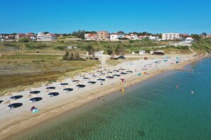 A beach with clear water, umbrellas, and people. - Apartment Sandstrand 4 with Sea View (Nin)