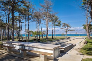 A park with picnic tables, benches, and a view of a lake and mountains. - Apartment Sandstrand 4 with Sea View (Nin)