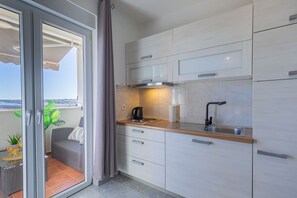 Eine moderne Küche mit einer Holzarbeitsplatte, einem integrierten Kochfeld und einem Spülbecken.