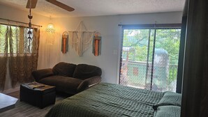 A bedroom with a bed, a chair, a ceiling fan, and a window with curtains. - Welcome to the HIPPY HAVEN nothing but good vibes (Lake Ozark)