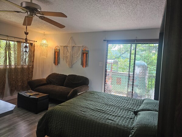 A bedroom with a bed, a chair, a ceiling fan, and a window with curtains. - Welcome to the HIPPY HAVEN nothing but good vibes (Lake Ozark)