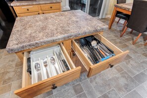 Eine Küche mit Granit-Arbeitsplatten, Holitschüben und Fliesenboden.