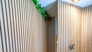 A corridor with vertical wooden slats and a dark floor, leading to a door with a 'WC' sign. - Black Forest Getaway | Private Sauna, Massage Chair & Views 🌲 (Schönwald im Schwarzwald)
