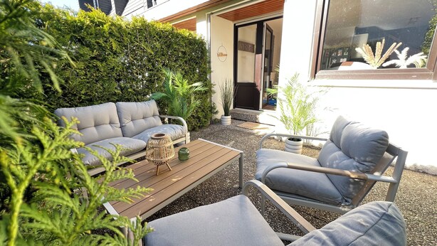 A patio with a sofa, a chair, and a table. - Black Forest Getaway | Private Sauna, Massage Chair & Views 🌲 (Schönwald im Schwarzwald)