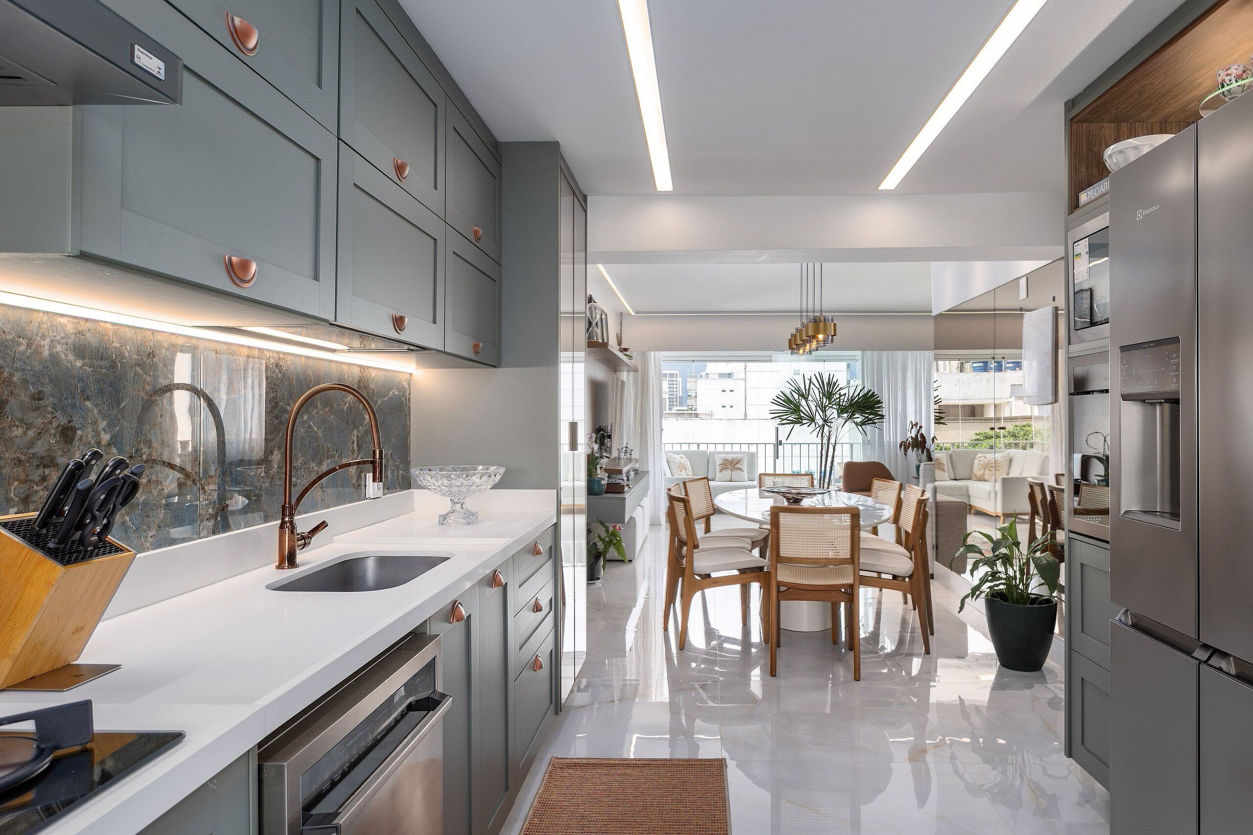 A modern kitchen with grey cabinets, stainless steel appliances, and a central island with seating.