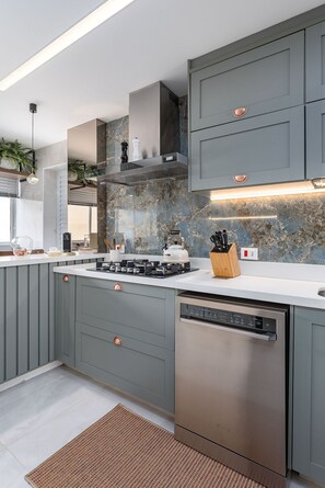 A modern kitchen with grey cabinets, a stainless steel dishwasher, and a marble backsplash. - 3-Bedroom Apartment 400m from Ipanema Beach (Rio de Janeiro)