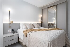 A bedroom with a bed, bedside table, lamp, and mirror. - 3-Bedroom Apartment 400m from Ipanema Beach (Rio de Janeiro)