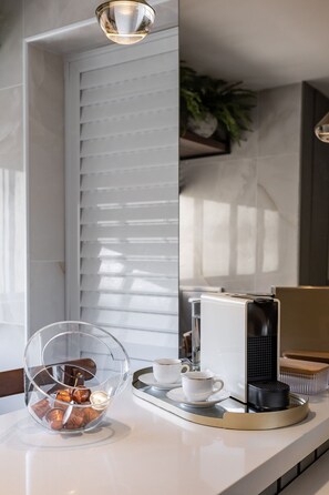 A modern kitchen with a coffee machine, a glass coffee pot, and a tray with a cup and saucer. - 3-Bedroom Apartment 400m from Ipanema Beach (Rio de Janeiro)