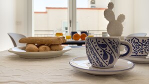 Un desayuno con un plato de galletas, una taza y un platito sobre una mesa.