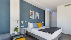 Un dormitorio moderno con cama, mesitas de noche, una planta en maceta y arte abstracto en la pared.
